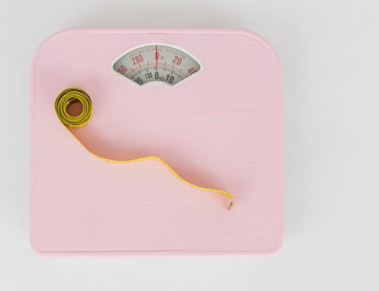 Top view of floor scales for weight control and measuring tape for controlling body shapes on white background