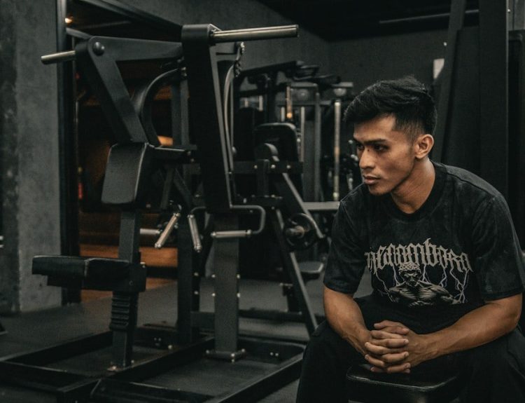 A man sitting on a bench in a gym
