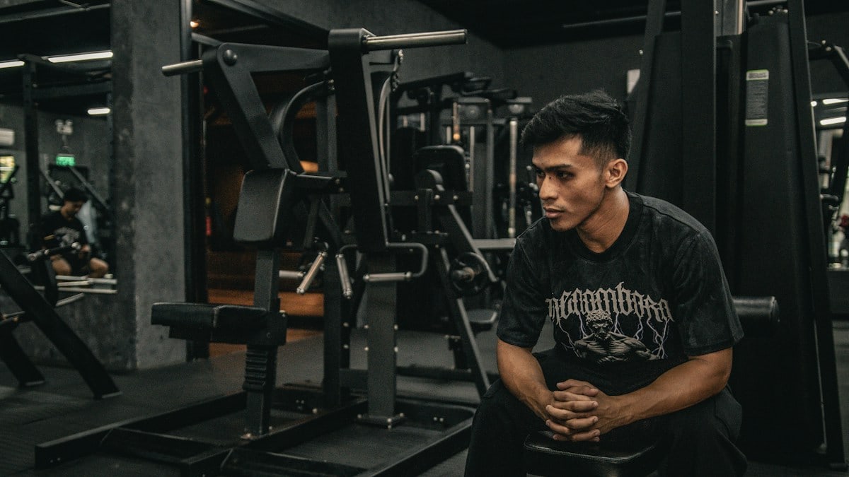 A man sitting on a bench in a gym